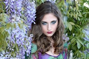 beatuful model posing among violet flowers