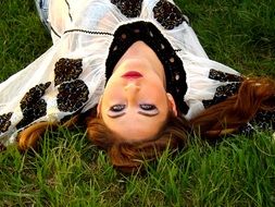 girl lying on her back on the grass