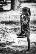 little girl on a swing in black and white image