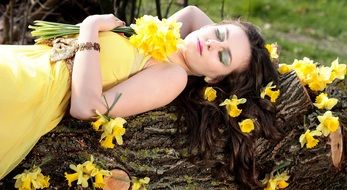 beautiful girl with a bouquet of yellow daffodils on a tree