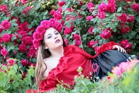 young woman posing on the rose bush background