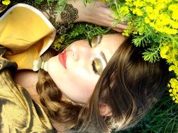 beautiful girl sleeps on yellow flowers close-up