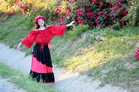 picture of woman in red rose wreath walking on the rural road