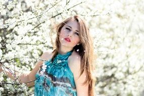 young woman in blue dress in the spring garden