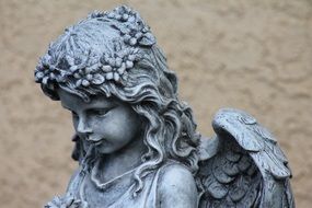 beautiful statue of an angel with a stone wreath on his head