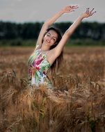 beautiful girl among the field in tall grass