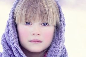 Portrait of blonde girl with blue eyes in winter
