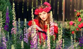 woman with rose wreath among garden flowers