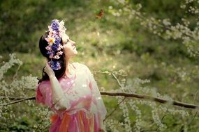 woman in colorful dress with floral wreath among the colorful nature