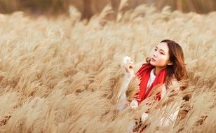 photo of a girl in a red scarf on a reed field
