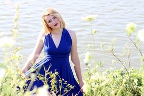 beautiful girl in a blue dress near the lake