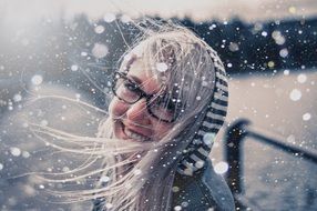 photo portrait of a girl with glasses during a snowfall