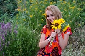 girl with sunflowers among flowering plants