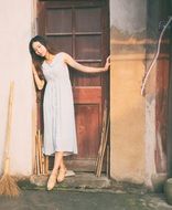 girl in a white dress near the wooden door