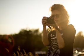 photographer with a camera in the background of the bright sun