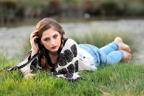 young woman resting on the green grass