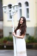 girl in white dress with white lantern on the street in Germany