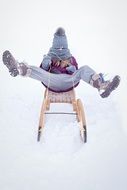 child sledding in the snow