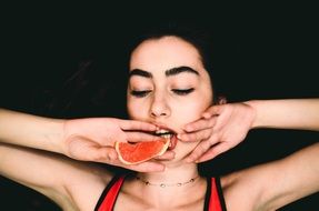 girl posing with fruit in hand