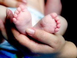 legs of a newborn in hand
