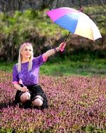 girl with a colorful umbrella in a flower meadow