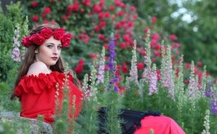 nice model in rose wreath among the colorful flowers