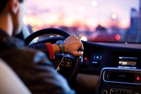 man's hand on the wheel of a car