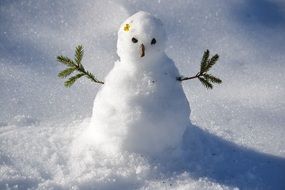small snowman in sunny winter day