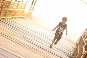 boy runs over the bridge