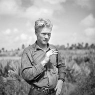 Black and white old photograph of a farmer with a cigarette on the field