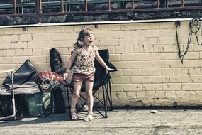 little girl on a chair near the wall in the stadium