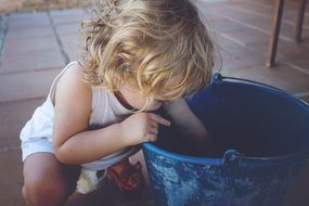 Small Child playing with blue bucket