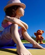 child Girl sits beside of Cartoon Bear Sculpture