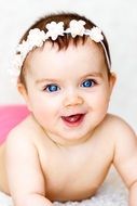 a small child looks and smiles at the camera