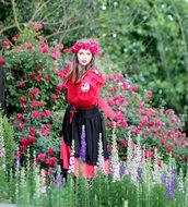 girl in a pink wreath among flowers