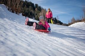 children ride a snow slide