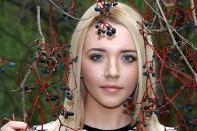 portrait of a blue-eyed blonde on a background of autumn berries