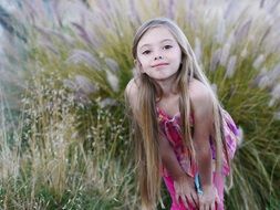 adorable girl with flowing hair on the background of grass