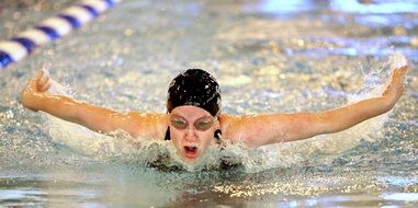 girl swims in the pool in competitions