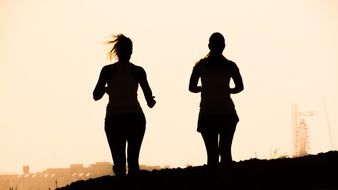 silhouettes of running women