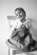 black and white photo of a cute girl sitting on a chair
