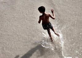 Child is playing with the water in summer