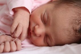 Newborn baby sleeping on a white bed