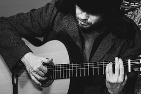 man in Russian hat playing guitar