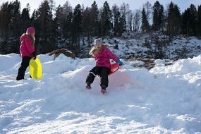 children play in the snow in winter