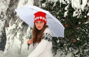 young woman in winter forest with umbrella