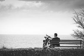 Monochrome photo of Man sitting on a bench