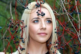 portrait of a blonde among black berries