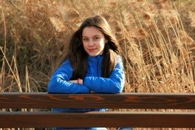 girl stands near the fence