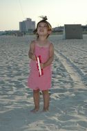 little girl on a sandy beach with a kite